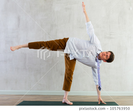 Young businessman doing yoga in office Young businessman doing yoga in office 105763950