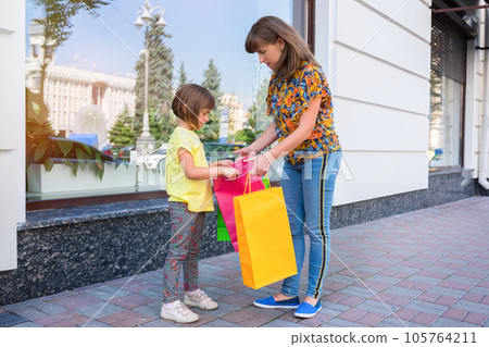Mother and the daughter with purchases on the city street 105764211