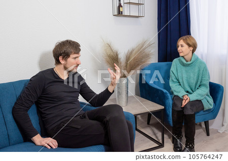 A man sitting on the couch, in consultation with a psychologist in the office A man sitting on the couch, in consultation with a psychologist in the office 105764247