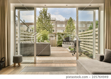 a living room with sliding glass doors that open up to the patio and backyard area in front of the house 105764949