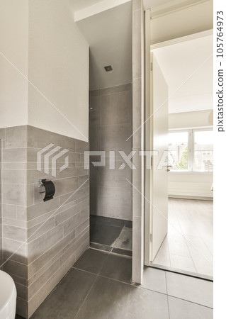 a bathroom with a toilet and shower stall on the floor in front of an open door that leads to a walk - in shower 105764973