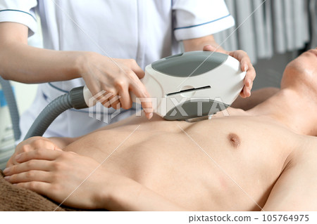 Therapist and male patient performing chest hair removal treatment Therapist and male patient performing chest hair removal treatment 105764975