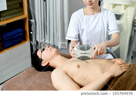 Therapist and male patient performing chest hair removal treatment Therapist and male patient performing chest hair removal treatment 105764976
