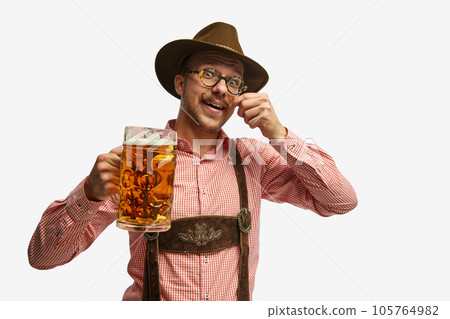 Portrait of attractive young man in hat, wearing folk Bavarian clothes, holding beer mug isolated white background. Concept of Oktoberfest 105764982