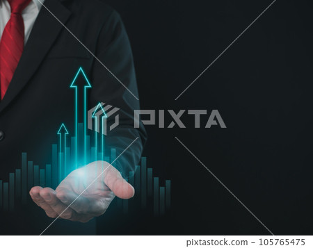 Stock trading. Finance. Investing. Growing business. Businessman in suit showing finger pointing to arrow tip on gray background. Stock trading. Finance. Investing. Growing business. Businessman in suit showing finger pointing to arrow tip on gray background. 105765475