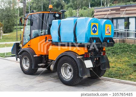 small tank truck for cleaning paths and watering plants in the city park small tank truck for cleaning paths and watering plants in the city park 105765485