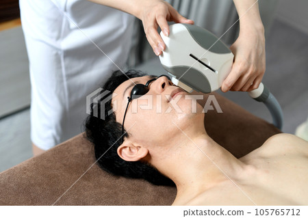 Therapist and male patient performing beard hair removal treatment Therapist and male patient performing beard hair removal treatment 105765712