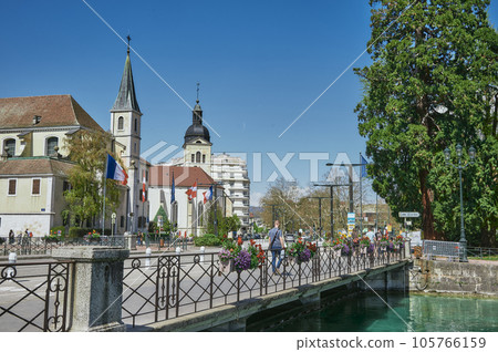 Tourists relaxing on the lakeside of Lake Annecy in a sunny day. 105766159