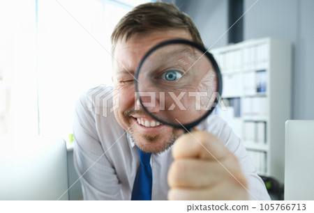 Smiling businessman hold magnifying glass 105766713