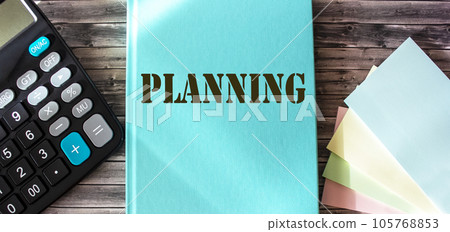 Marketing plan written on a turquoise notepad, office wooden table with a calculator and stickers 105768853