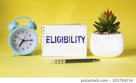Text Eligibility on notepad and yellow background with clock, cactus Text Eligibility on notepad and yellow background with clock, cactus 105769234