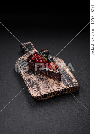 Delicious sweet chocolate brownie cake with blueberries, currants and raspberries Delicious sweet chocolate brownie cake with blueberries, currants and raspberries 105769251
