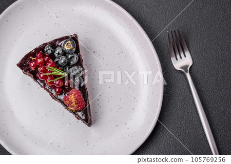 Delicious sweet chocolate brownie cake with blueberries, currants and raspberries Delicious sweet chocolate brownie cake with blueberries, currants and raspberries 105769256