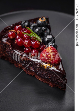 Delicious sweet chocolate brownie cake with blueberries, currants and raspberries 105769328