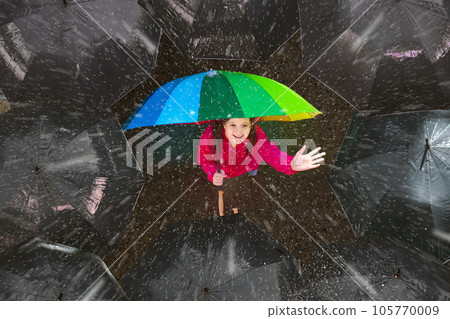 Girl under colorful umbrella in dark crowd. Girl under colorful umbrella in dark crowd. 105770009