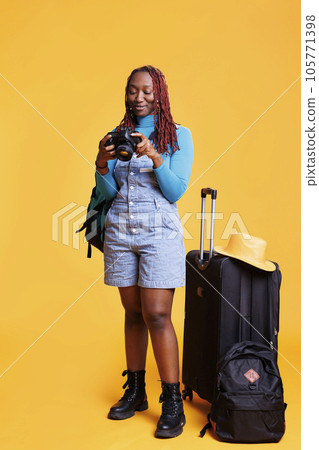 African american girl with dslr camera taking photos of buildings architecture and scenic route. Tourist capturing pictures of landscapes and landmarks with trolley bags and suitcases. 105771398