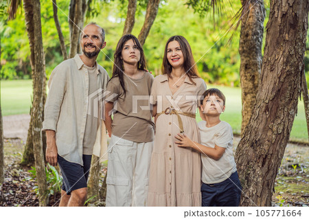 A loving family enjoying a leisurely walk in the park - a radiant pregnant woman after 40, embraced by her husband, and accompanied by their adult teenage children, savoring precious moments together A loving family enjoying a leisurely walk in the park - a radiant pregnant woman after 40, embraced by her husband, and accompanied by their adult teenage children, savoring precious moments together 105771664