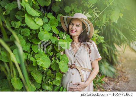 A serene and radiant pregnant woman after 40, surrounded by nature's beauty in the park, cherishing the journey of motherhood with a glowing smile A serene and radiant pregnant woman after 40, surrounded by nature's beauty in the park, cherishing the journey of motherhood with a glowing smile 105771665