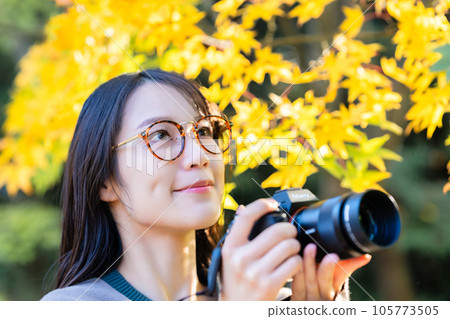 Camera girl shooting autumn leaves Camera girl shooting autumn leaves 105773505