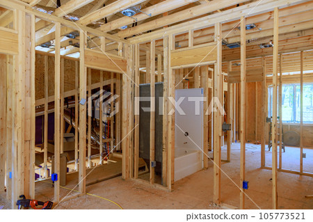 Bathroom remodel under plumbing work connecting installation of pipes with installed new acrylic bathtub for new house Bathroom remodel under plumbing work connecting installation of pipes with installed new acrylic bathtub for new house 105773521