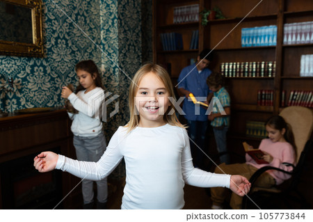 Cheerful preteen girl having fun in quest room with friends 105773844