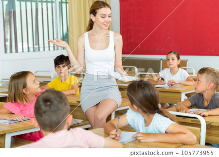 Young attractive female teacher giving lesson to children Young attractive female teacher giving lesson to children 105773955