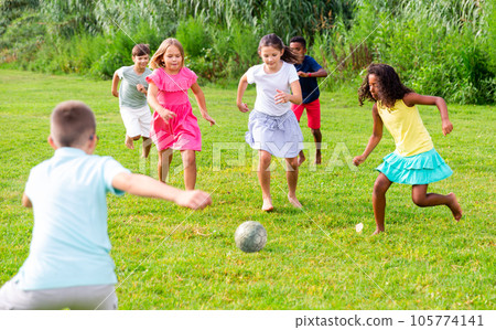 Group of kids playing football on grass Group of kids playing football on grass 105774141