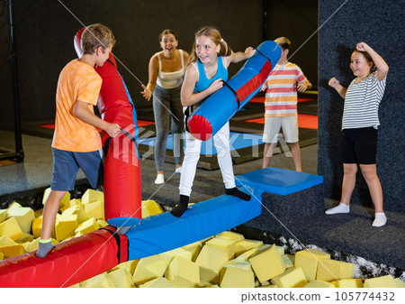 Teen girl having fun on battle beam with preteen brother Teen girl having fun on battle beam with preteen brother 105774432