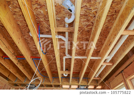 Installing pvc plastic drain pipe water piping system for new home during under construction 105775822