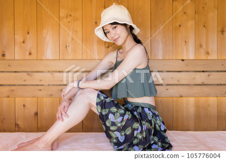Sauna girl wearing a sauna hat and entering an outdoor sauna Sauna girl wearing a sauna hat and entering an outdoor sauna 105776004