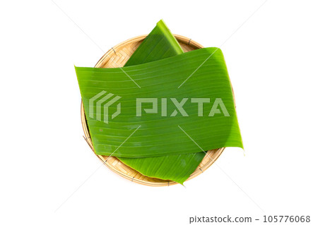 Banana leaves in bamboo weave plate on white background. Banana leaves in bamboo weave plate on white background. 105776068