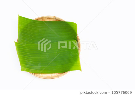 Banana leaves in bamboo weave plate on white background. 105776069