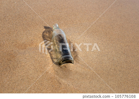 Glass bottle on the beach 105776108