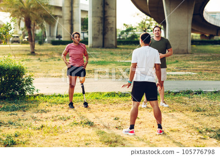 Friend support Friend with a prosthetic leg while exercising outdoor. 105776798