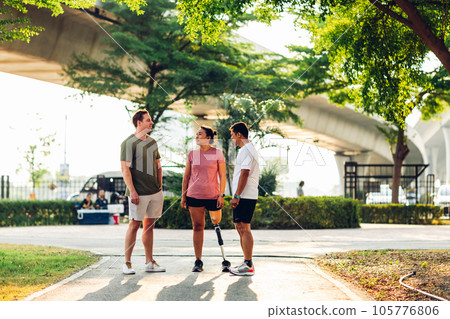 Friend support Friend with a prosthetic leg while exercising outdoor. 105776806