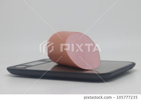pork sausage on electronic kitchen scale isolated on white background. Sausage on a cutting board pork sausage on electronic kitchen scale isolated on white background. Sausage on a cutting board 105777235
