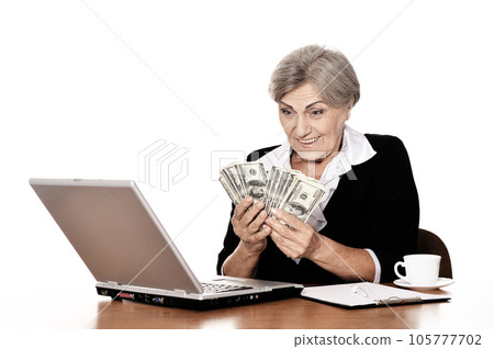 old woman holding dollars on white background 105777702
