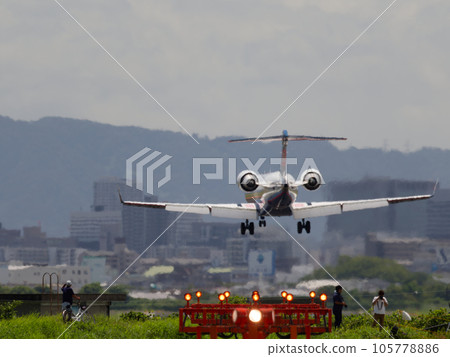 跑道盡頭河岸上的引導燈、飛機降落、人們觀看拍照 105778886