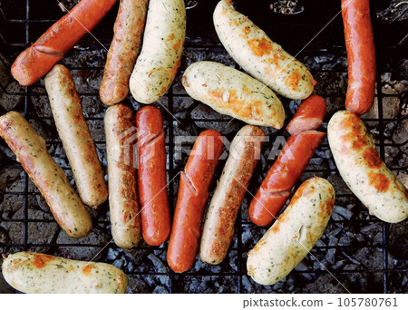 Fried sausages smoked on the grill over hot coals Fried sausages smoked on the grill over hot coals 105780761
