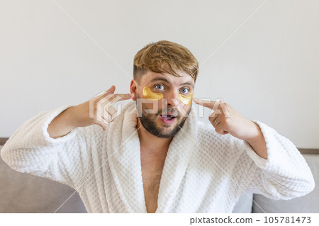 Beauty treatments, skin care, metrosexual concept. A handsome bearded man with golden bandages under his eyes makes funny faces with facial expressions 105781473
