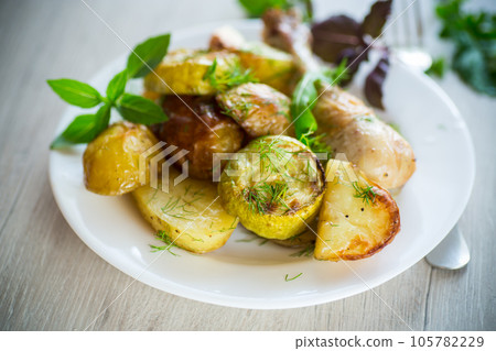 Early baked potatoes with zucchini and chicken 105782229