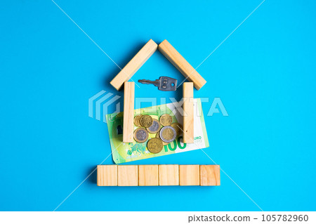 Wooden house model with coins, money, copy space on blue background. 105782960