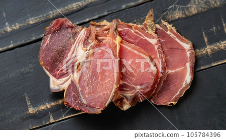 photo of dried sliced lamb meat on black wooden surface top view photo of dried sliced lamb meat on black wooden surface top view 105784396