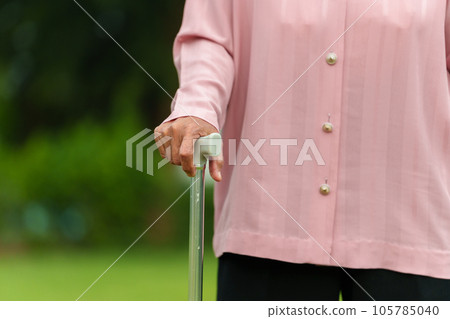 close up senior woman with walking stick in park 105785040