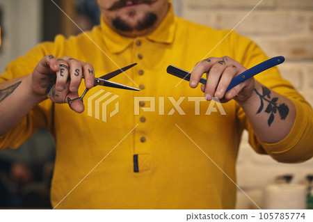 Stylish barber man with hairdressing tools in his hands prepare for work Stylish barber man with hairdressing tools in his hands prepare for work 105785774