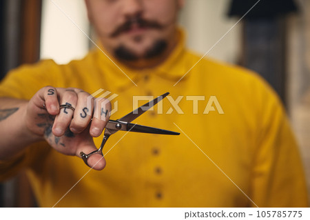 Stylish barber man with hairdressing tools in his hands prepare for work Stylish barber man with hairdressing tools in his hands prepare for work 105785775