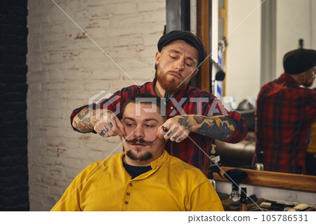 Client during beard shaving in barber shop Client during beard shaving in barber shop 105786531