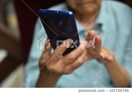 操作智能手機的老年人的手 操作智能手機的老年人的手 105786786