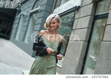 Fashion. Young stylish woman walking on the city street looking down laughing playful 105787868