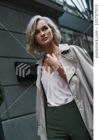 Fashion. Young stylish woman walking on the city street looking aside pensive close-up 105787915